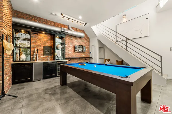 a room with pool table and stainless steel appliances