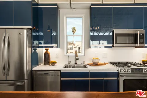 a kitchen with stainless steel appliances a stove microwave and refrigerator