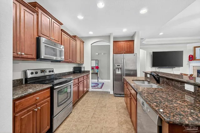 a kitchen with stainless steel appliances granite countertop a stove a sink and a refrigerator