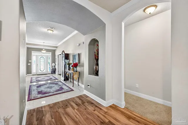 a view of a hallway with workspace and bedroom with furniture
