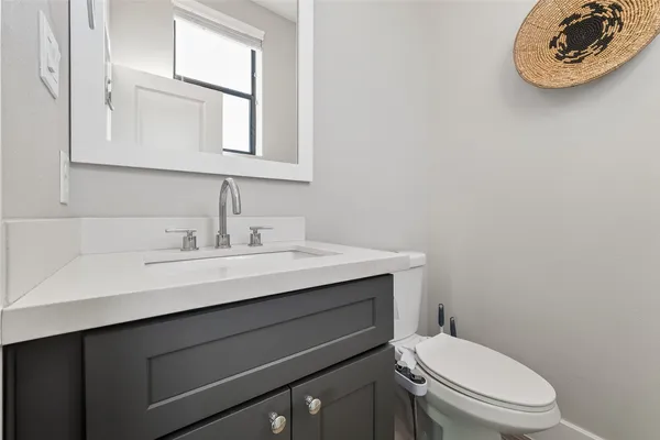 a bathroom with a toilet a sink and mirror