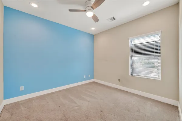 an empty room with a window and a fan