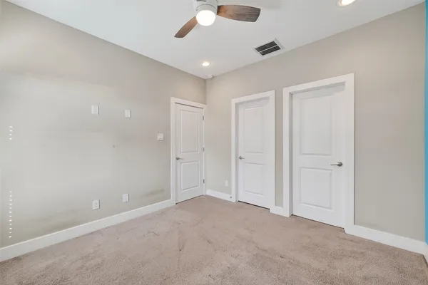 an empty room with a ceiling fan and a window