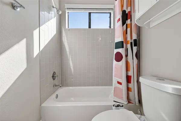 a white bath tub sitting next to a white toilet and sink
