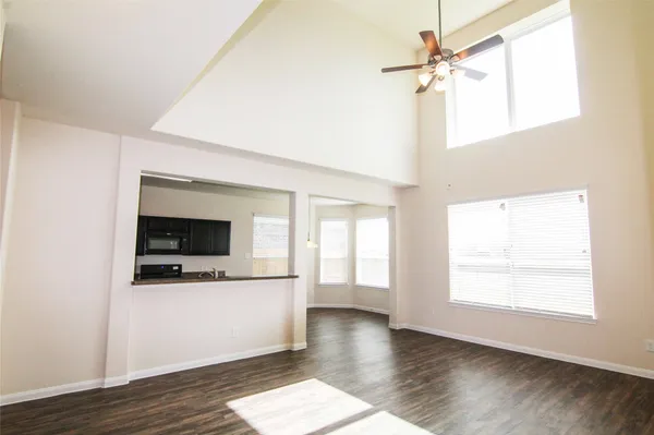 a view of a livingroom with wooden floor and a ceiling fan