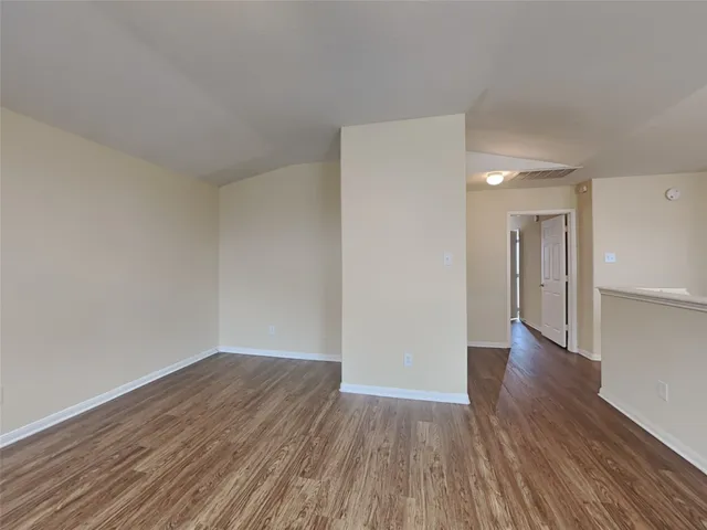 a view of a room with wooden floor and a window