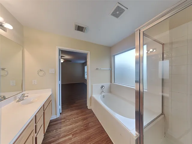 a bathroom with a bathtub and double vanity