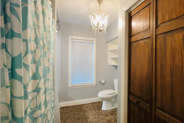a bathroom with a toilet a sink and a shower curtain