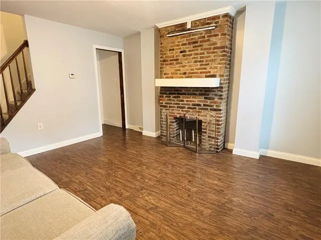 an empty room with wooden floor and a fireplace