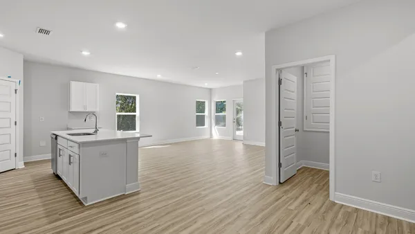 a kitchen with a sink and wooden floor