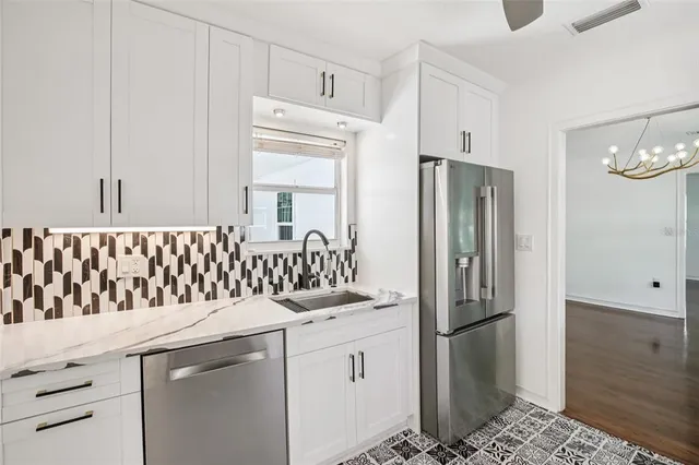 a kitchen with stainless steel appliances granite countertop a refrigerator and a stove