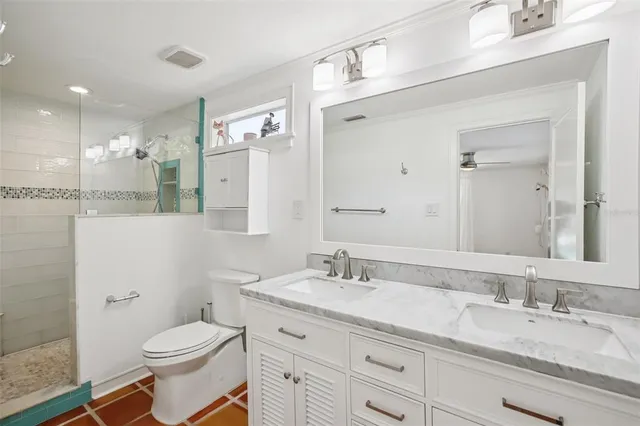 a bathroom with a granite countertop toilet sink and a mirror