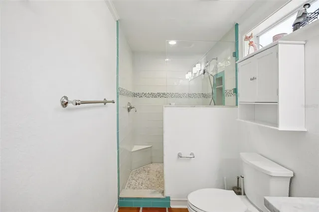 a bathroom with a toilet and a shower