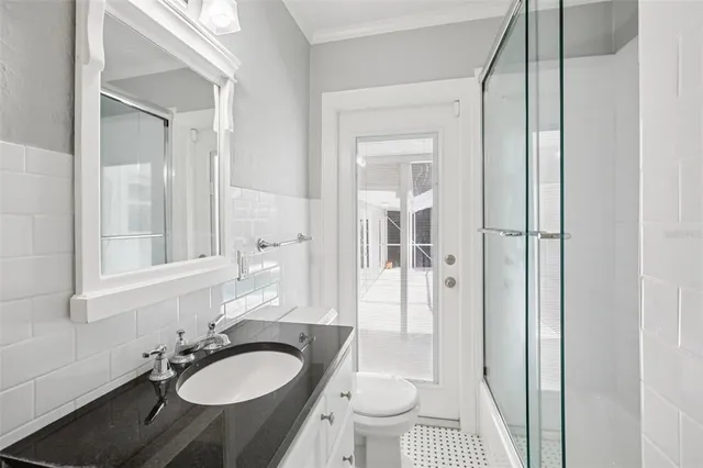 a bathroom with a granite countertop sink toilet and shower