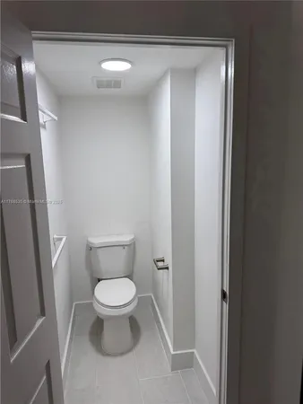 a white toilet sitting in a bathroom next to a sink