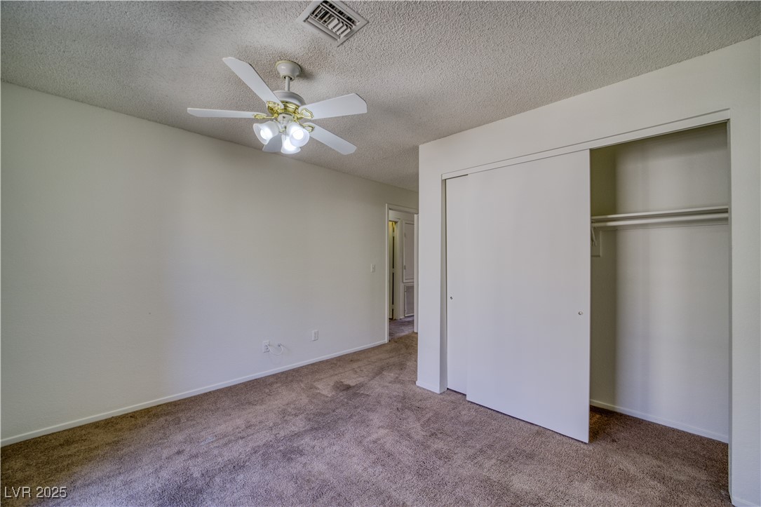 2232 Aspen Mirror Way, Unit 202 Laughlin, NV 89029 - Photo 26 of 39 Unfurnished bedroom featuring a textured ceiling, carpet flooring, a closet, and ceiling fan