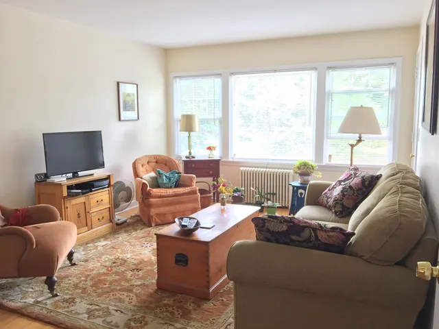 a living room with furniture a flat screen tv and a window