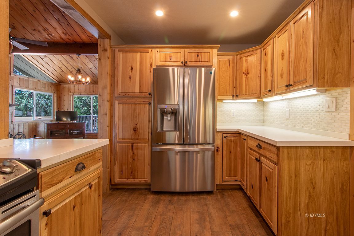 25104 Fern Valley Road Idyllwild, CA 92549 - Photo 13 of 55 a kitchen with stainless steel appliances granite countertop a refrigerator a sink dishwasher and wooden cabinets with wooden floor