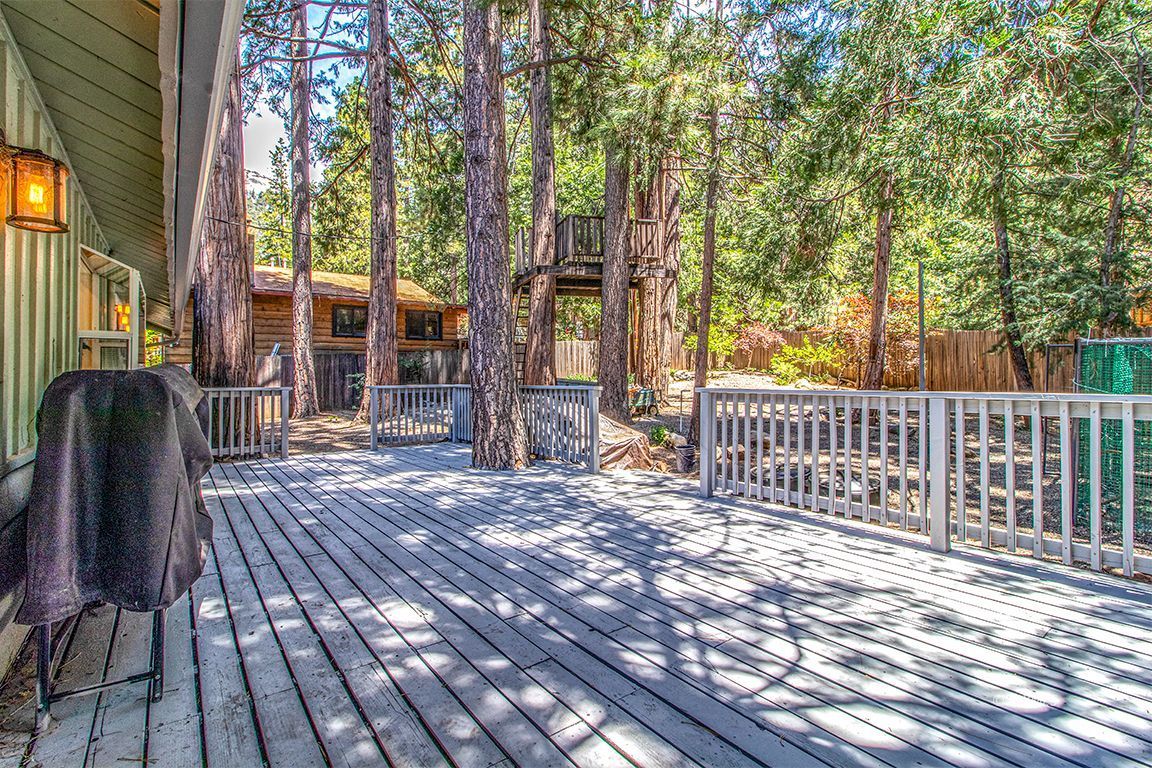 25104 Fern Valley Road Idyllwild, CA 92549 - Photo 37 of 55 a view of a deck with wooden floor and fence with a floor to ceiling window