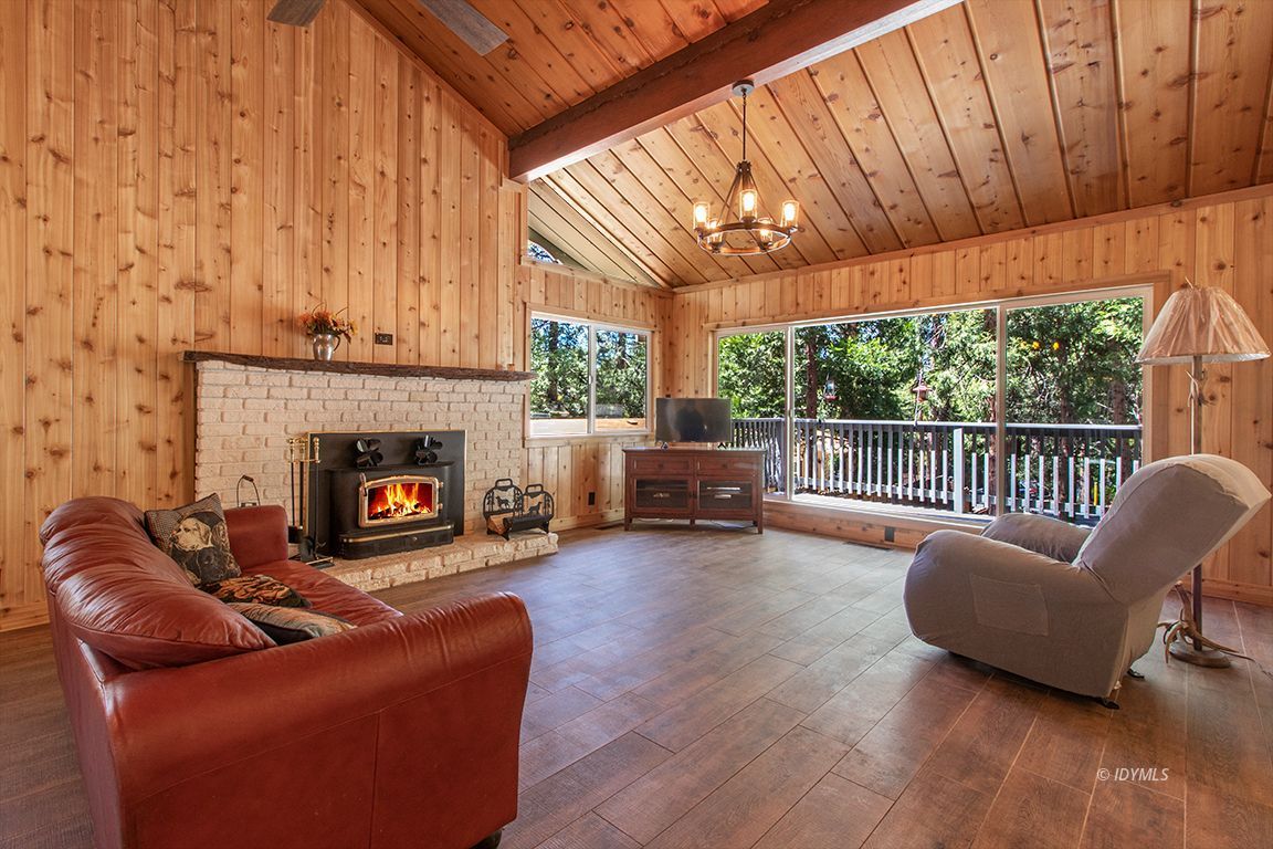 25104 Fern Valley Road Idyllwild, CA 92549 - Photo 4 of 55 a living room with furniture a fireplace and a floor to ceiling window