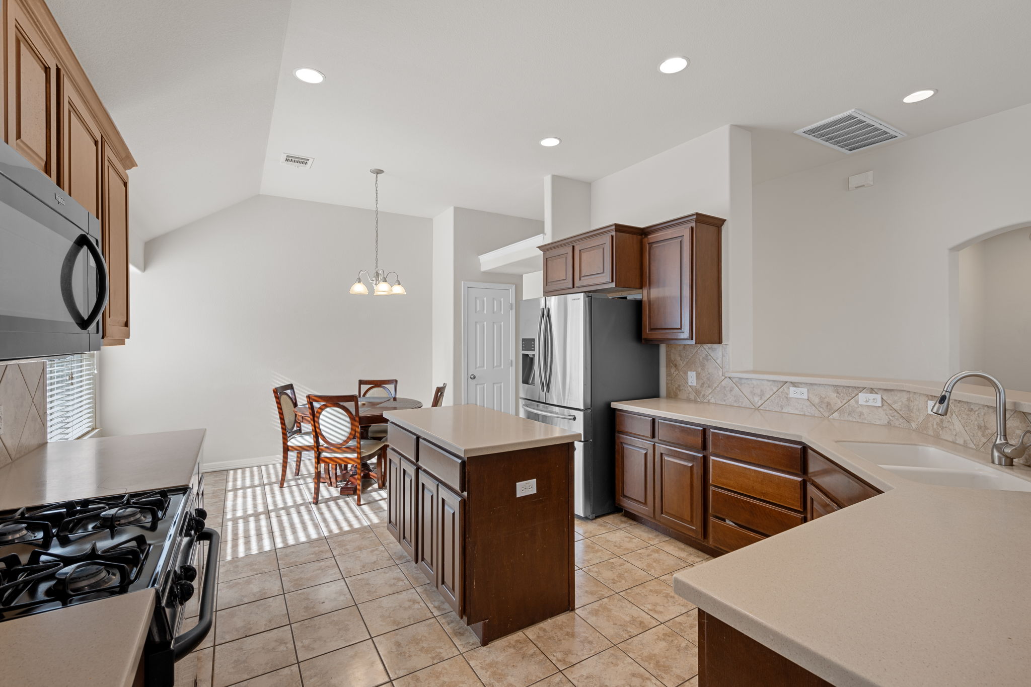 2221 Village View Loop Pflugerville, TX 78660 - Photo 9 of 25 a kitchen with stainless steel appliances granite countertop a sink a stove and a refrigerator