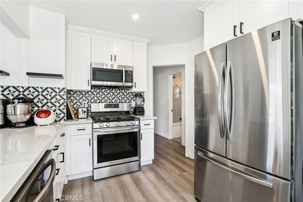a kitchen with stainless steel appliances a stove a refrigerator and a sink