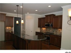 1066 Gardenia Street Fort Mill, SC 29708 - Photo 2 of 12 a kitchen with kitchen island granite countertop a sink cabinets and stainless steel appliances