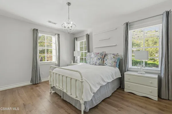 a bedroom with a large bed and a chandelier