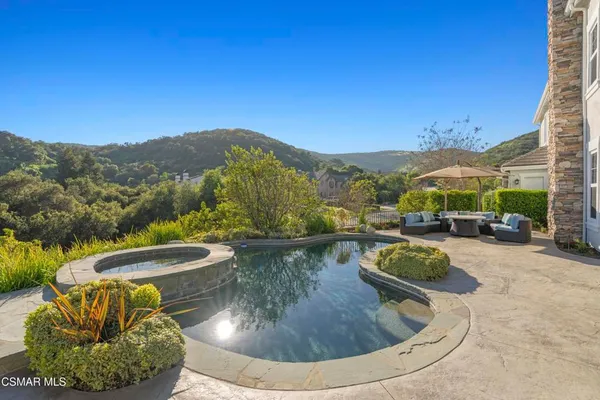 a view of a swimming pool with a patio and a garden