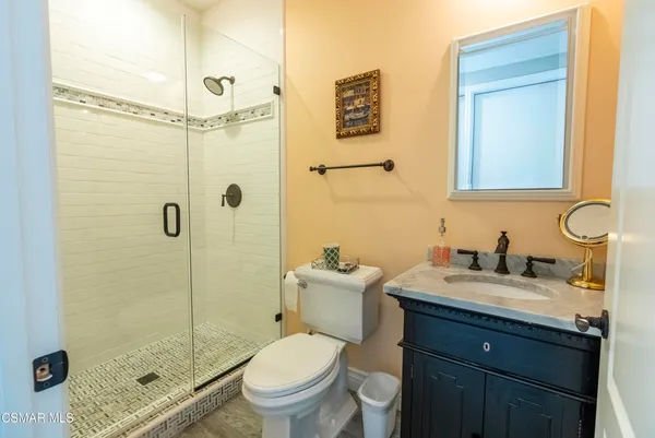a bathroom with a granite countertop sink toilet a mirror and shower