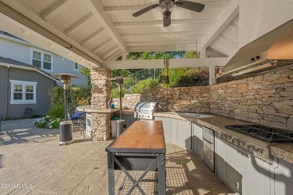 a kitchen with a sink a stove and chairs