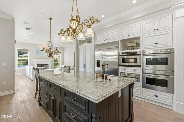 a kitchen with stainless steel appliances granite countertop a kitchen island a stove and a refrigerator