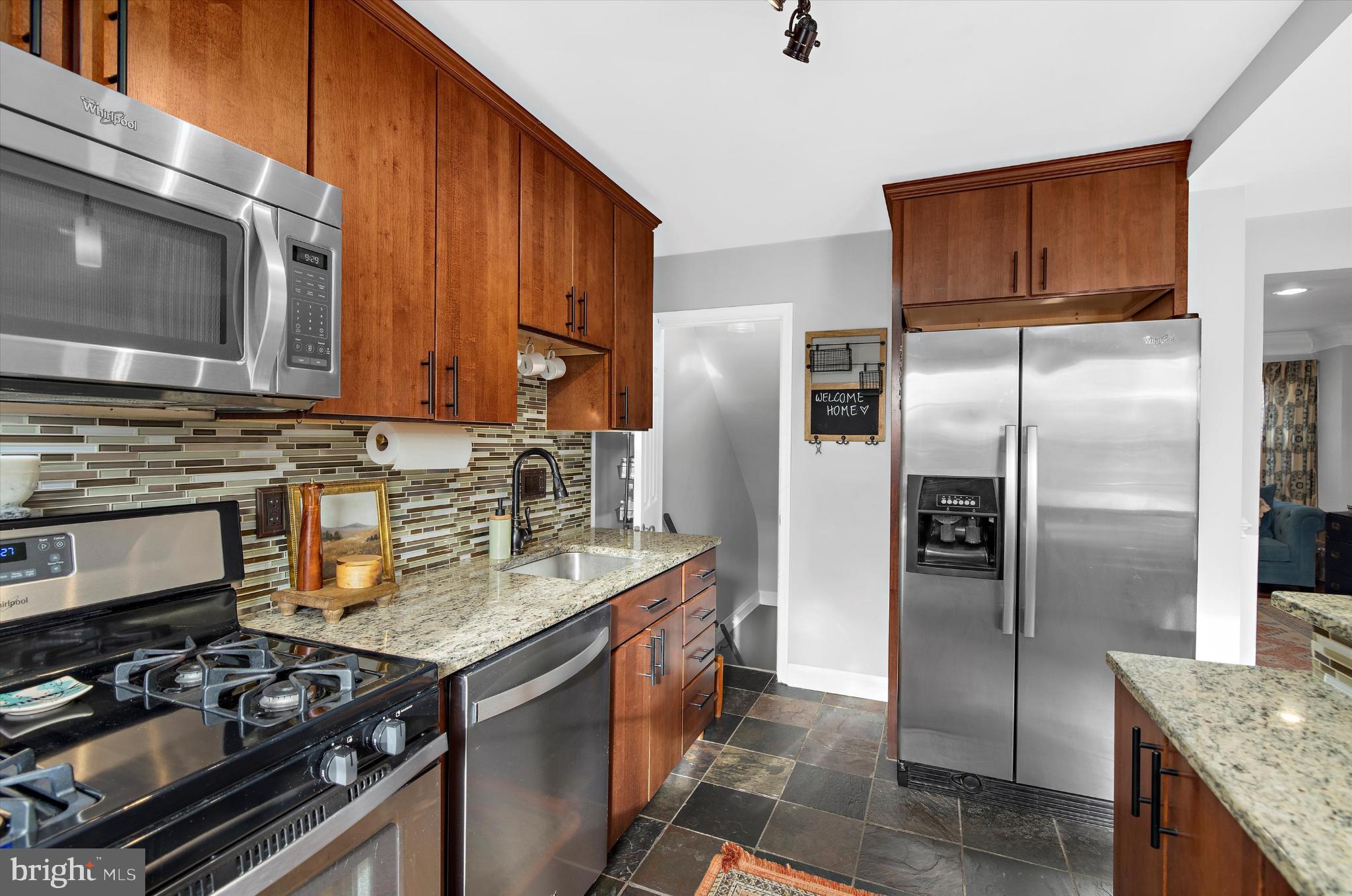 1215 Roland Heights Avenue Baltimore, MD 21211 - Photo 15 of 38 a kitchen with stainless steel appliances granite countertop a stove microwave refrigerator and sink