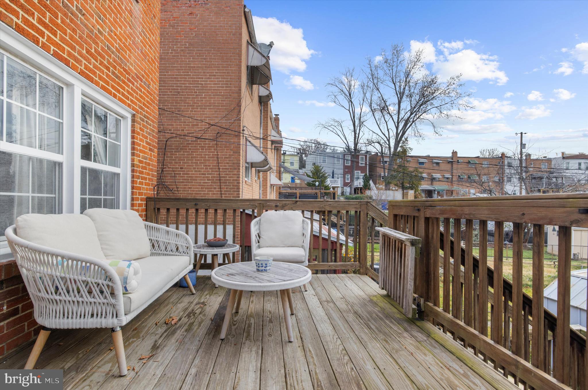 1215 Roland Heights Avenue Baltimore, MD 21211 - Photo 27 of 38 a view of a roof deck with table and chairs a barbeque with wooden floor and fence