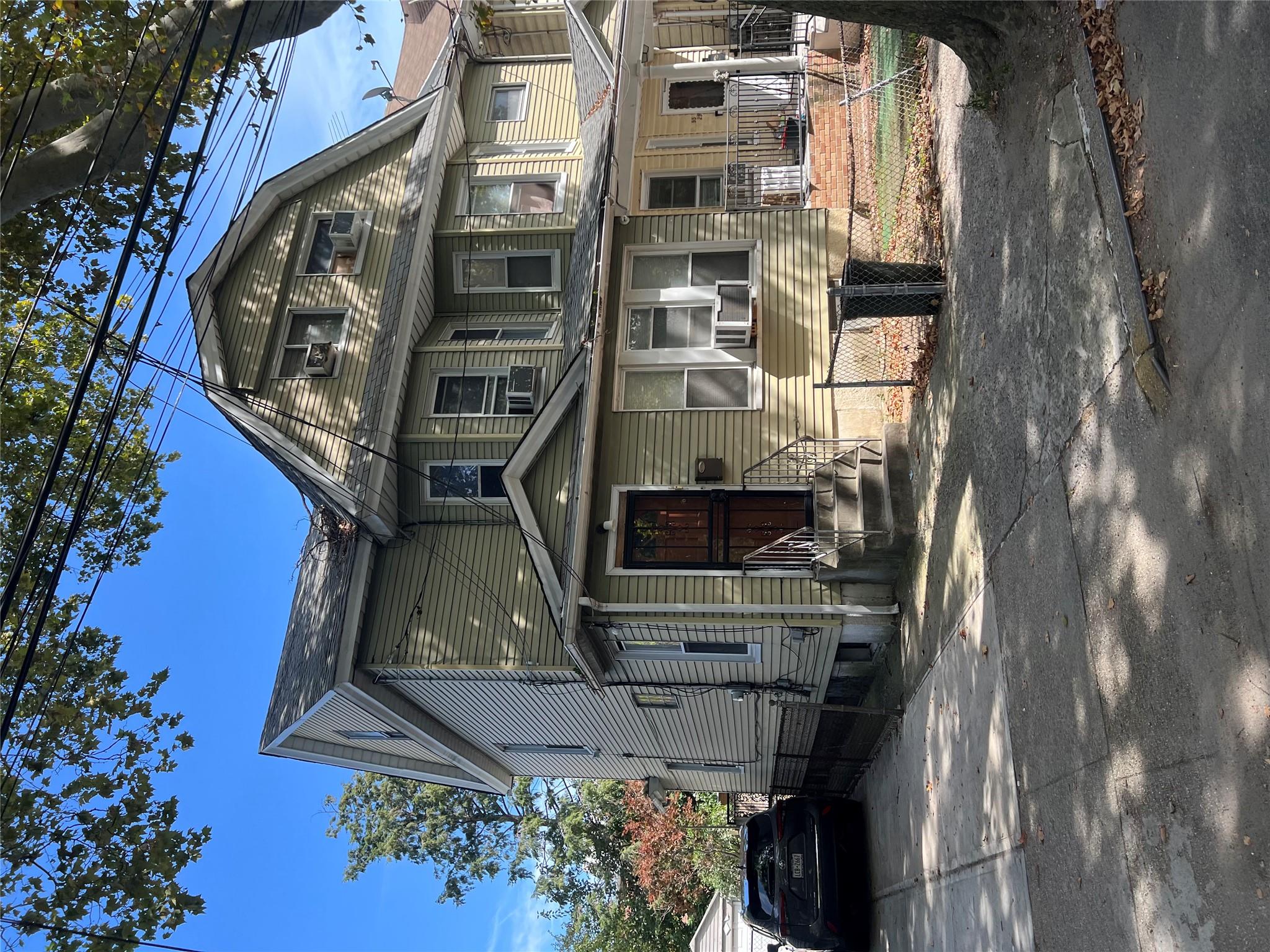 95-27 116th Street Queens, NY 11419 - Photo 2 of 2 a view of a big house with many windows and a car parked beside it