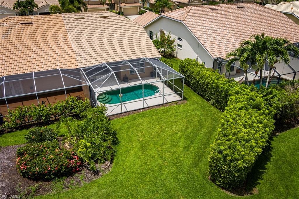 6658 Castlelawn Place, Unit 9 Naples, FL 34113 - Photo 33 of 38 Screened-in pool deck featuring a lagoon-style pool with integrated steps
