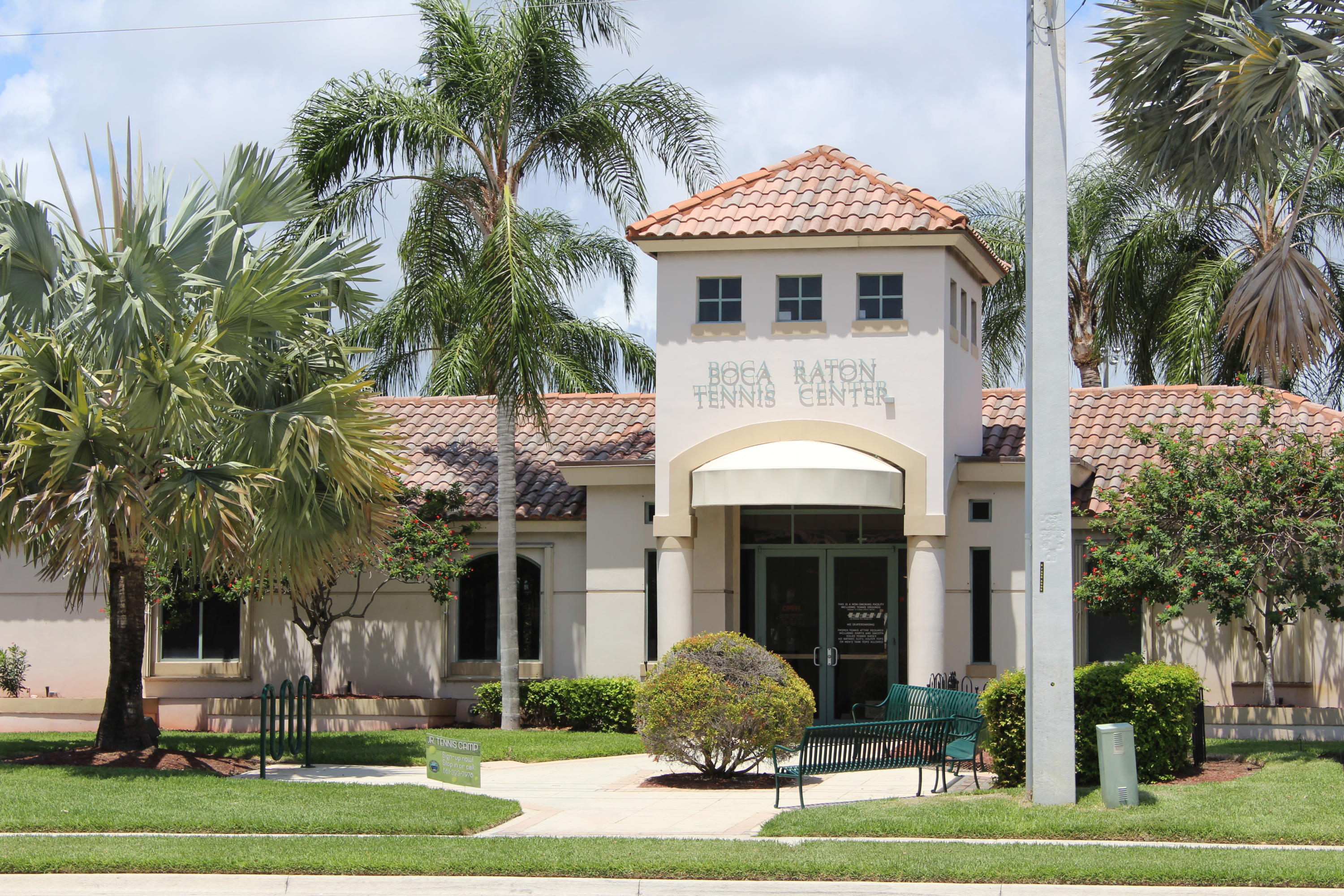145 Northwest Emerson Place Boca Raton, FL 33432 - Photo 35 of 35 a front view of a house with a garden and palm trees