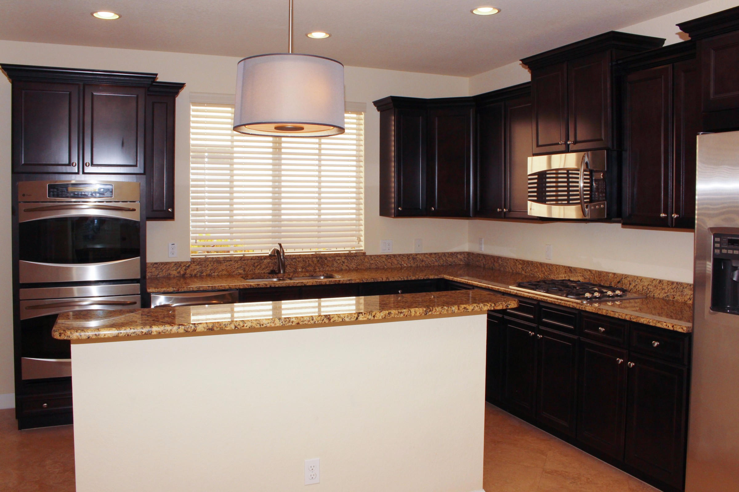 145 Northwest Emerson Place Boca Raton, FL 33432 - Photo 5 of 35 a kitchen with granite countertop wood cabinets and stainless steel appliances