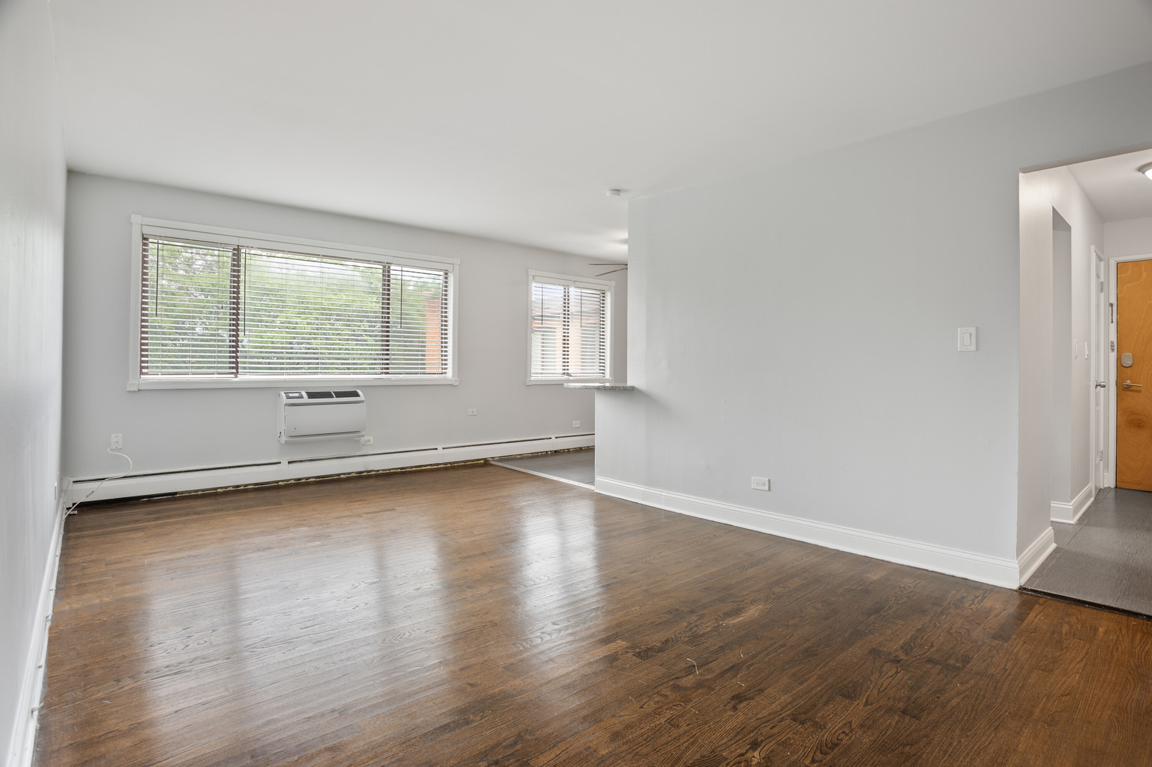 6826 North Ridge Boulevard, Unit 401 Chicago, IL 60645 - Photo 2 of 16 an empty room with wooden floor and windows