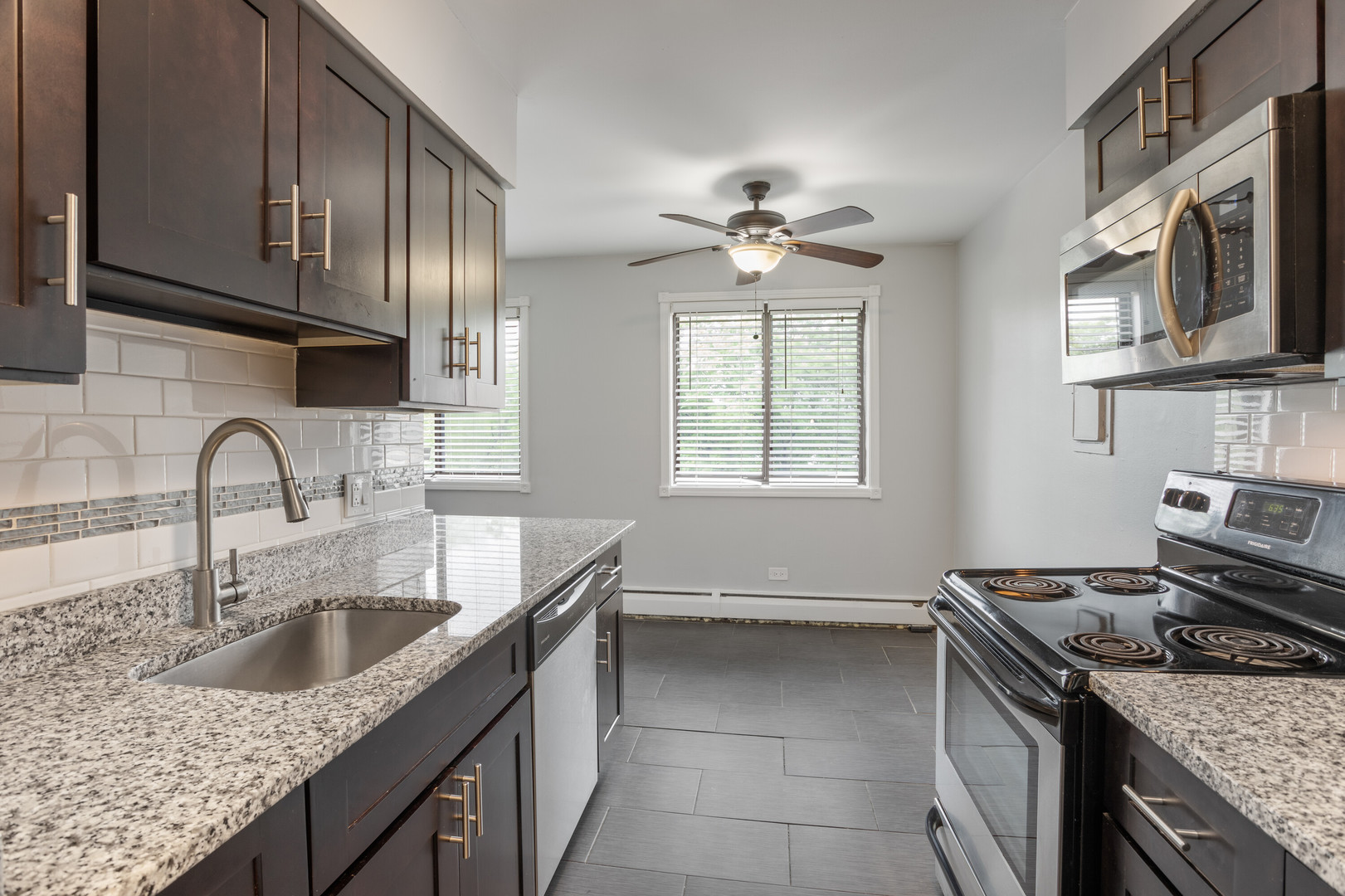 6826 North Ridge Boulevard, Unit 401 Chicago, IL 60645 - Photo 5 of 16 a kitchen with stainless steel appliances granite countertop a sink stove top oven and cabinets
