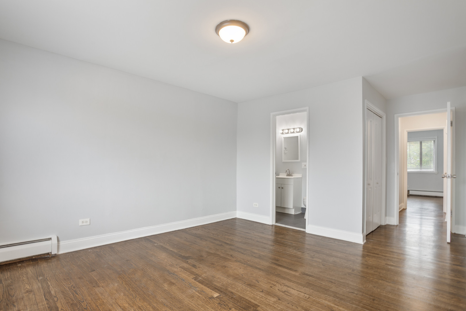 6826 North Ridge Boulevard, Unit 401 Chicago, IL 60645 - Photo 7 of 16 a view of an empty room with wooden floor and a window
