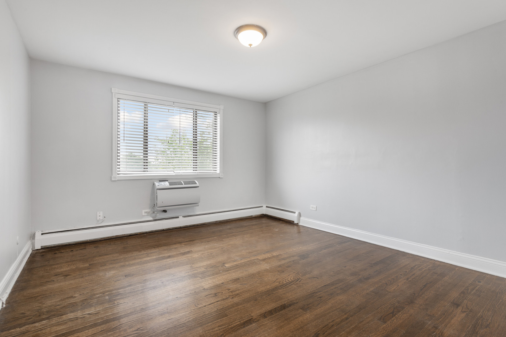 6826 North Ridge Boulevard, Unit 401 Chicago, IL 60645 - Photo 8 of 16 an empty room with wooden floor and windows