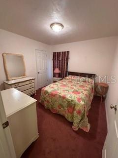 1527 Northeast 40th Place Gainesville, FL 32609 - Photo 14 of 19 a bedroom with a bed and a chandelier