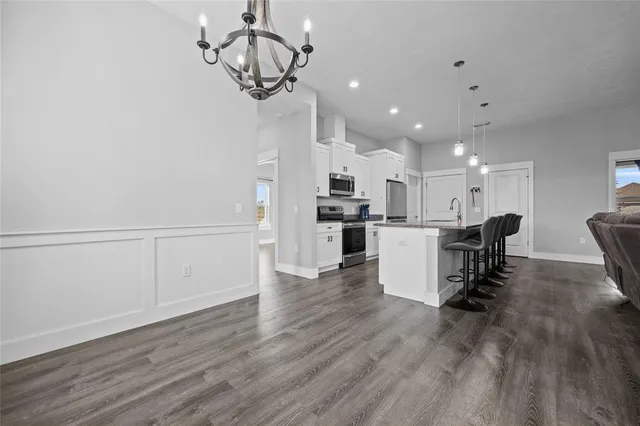a view of a livingroom with wooden floor and a ceiling fan