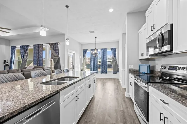 a large kitchen with stainless steel appliances granite countertop a lot of counter space and a sink