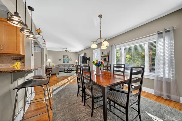 a view of a dining room and livingroom with furniture wooden floor a chandelier