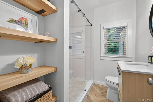a bathroom with a sink a toilet and a window