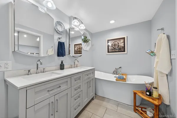 a spacious bathroom with a double vanity sink mirror and bathtub