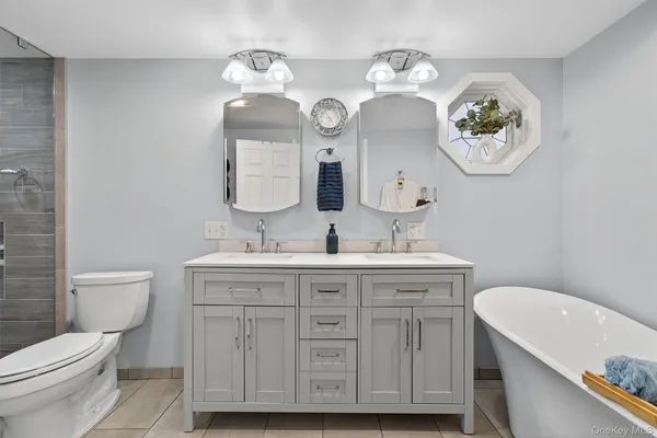 a bathroom with a granite countertop toilet a sink and a mirror