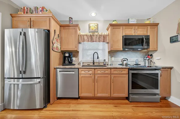 a kitchen with stainless steel appliances granite countertop a refrigerator microwave and sink